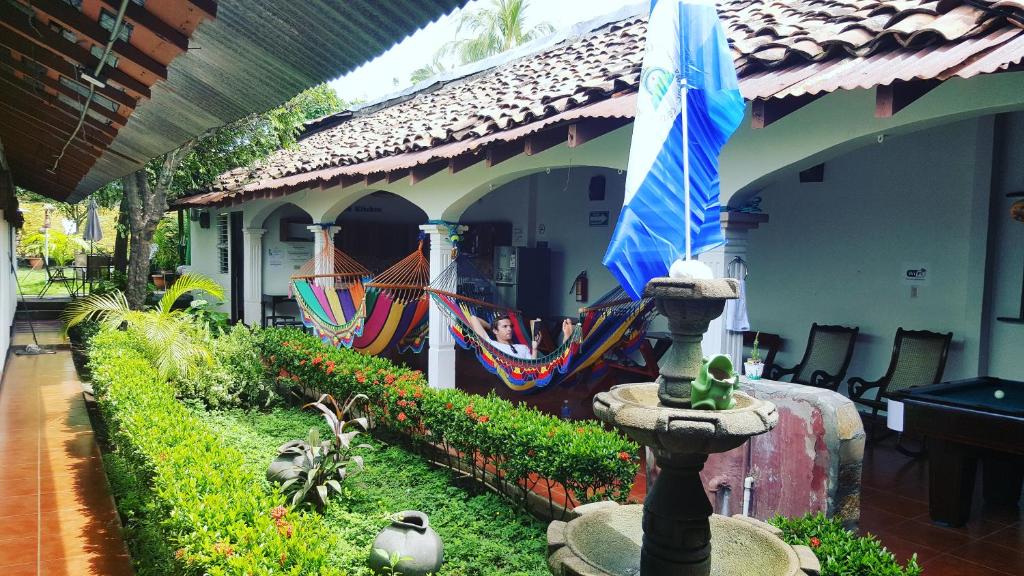 dom z parasolką i hamakami na podwórku w obiekcie Hostal El Jardin w mieście León