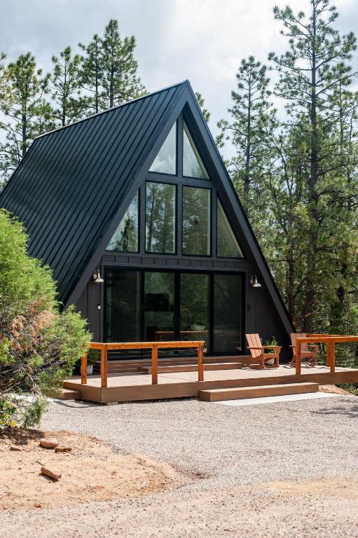 a house with a black roof with two benches at A-frame 10 Min to Downtown Durango in Durango
