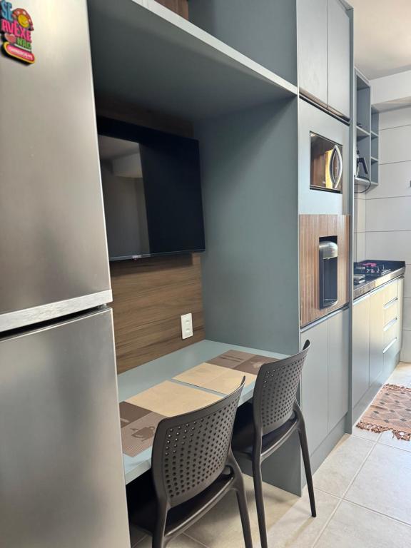 een kleine keuken met een tafel en 2 stoelen bij Apartamento na Praia dos Carneiros a 250m do mar in Praia dos Carneiros