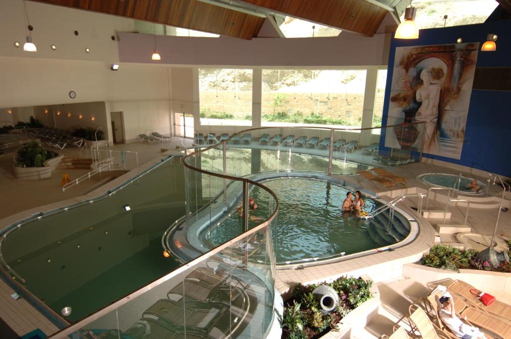 a large indoor swimming pool with people in the water at Royal Dead Sea - Hotel & Spa in Ein Bokek