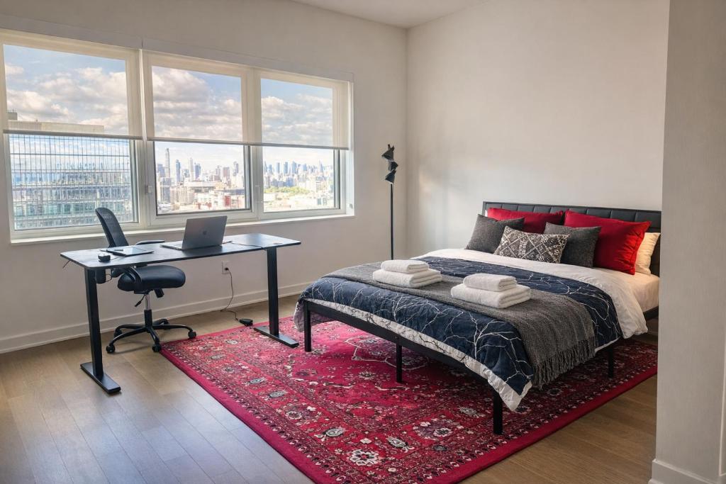 een slaapkamer met een bed en een bureau met een laptop bij Elegant Long Island City Studio with Skyline Views in Roosevelt Island