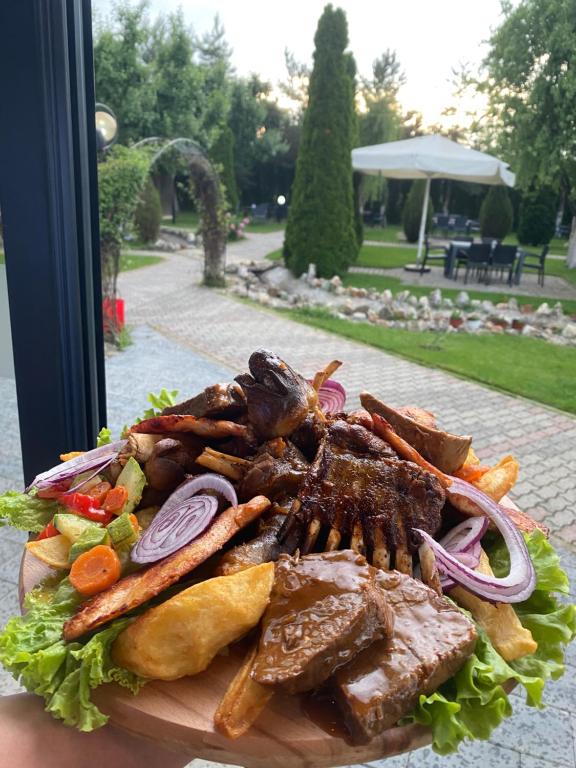 a plate of food with meat and vegetables at Hotel Restaurant Arena in Kastriot