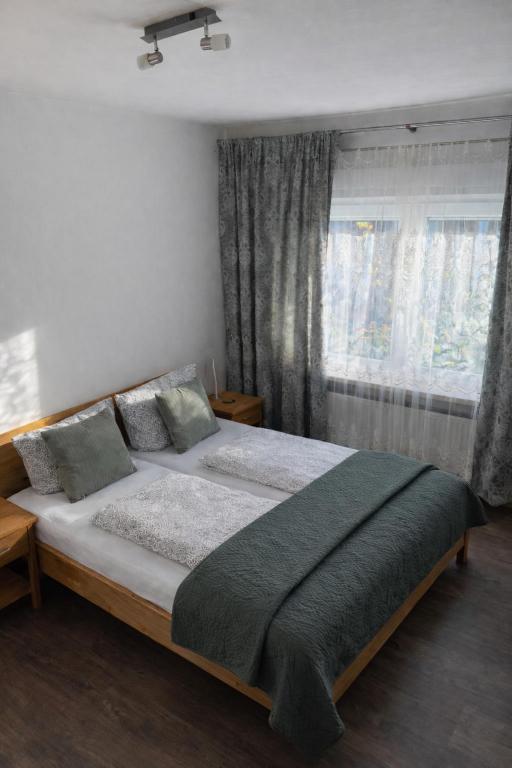 une chambre avec un grand lit devant une fenêtre dans l'établissement Ferienwohnungen Avenor, à Norden