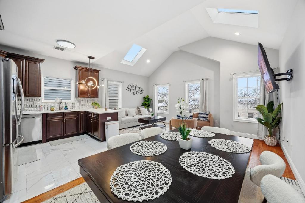 a kitchen and living room with a table and chairs at 4 BR • Vaulted Living • Sleeps 11 in Jersey City