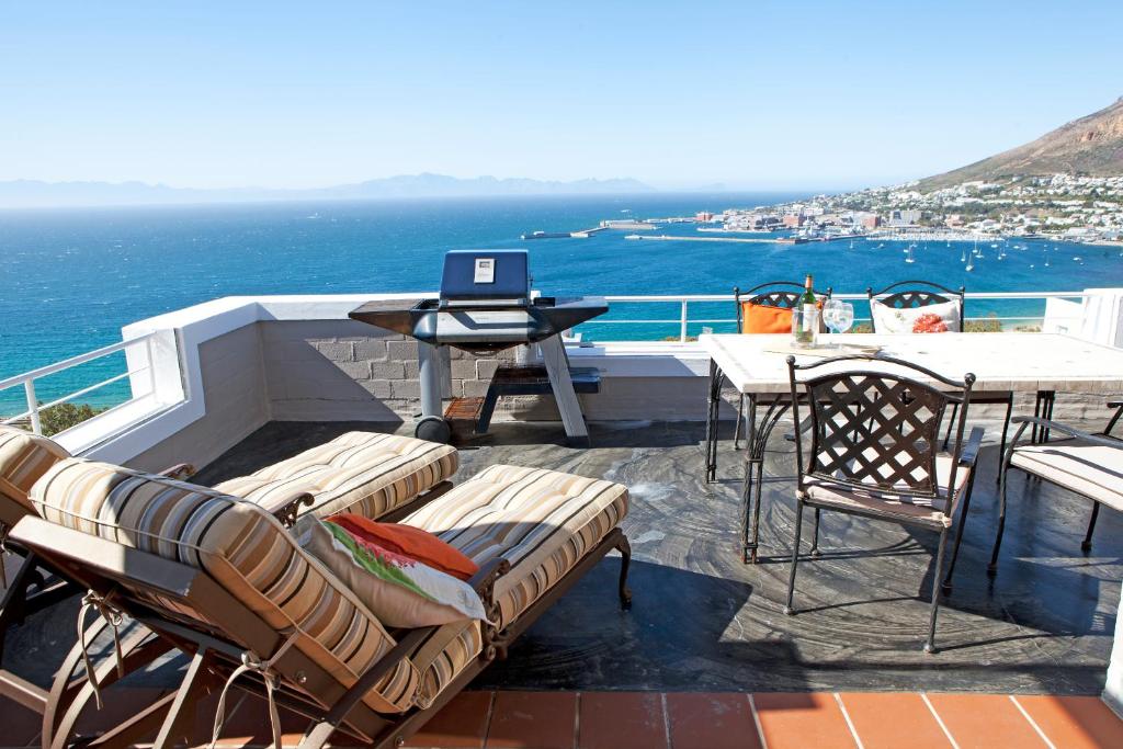 a balcony with a table and a laptop computer on it at Simonstown Penthouse in Simonʼs Town