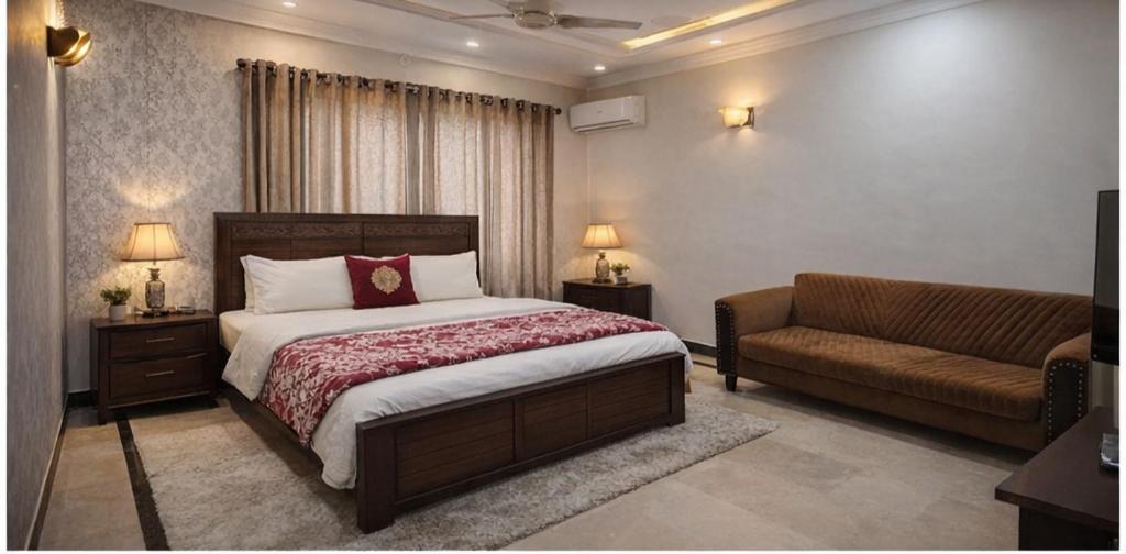 a bedroom with a bed and a couch at Komal Residency in Islamabad