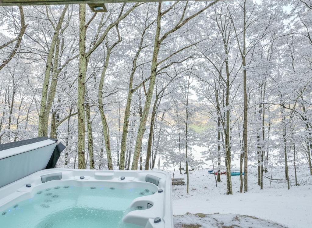 a bath tub in the snow in a forest at LUX Lakefront, Pool, Hot Tub, Game Room, FIFA 2026 in Bushkill