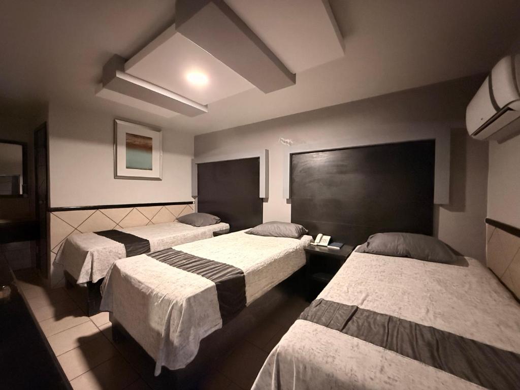 una camera d'albergo con tre letti di Hotel Las Vegas a Matamoros