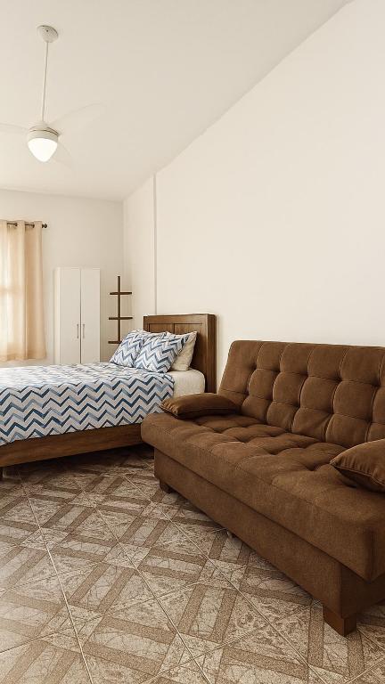 a living room with a couch and a bed at Kit net a poucos passos do mar in São Vicente