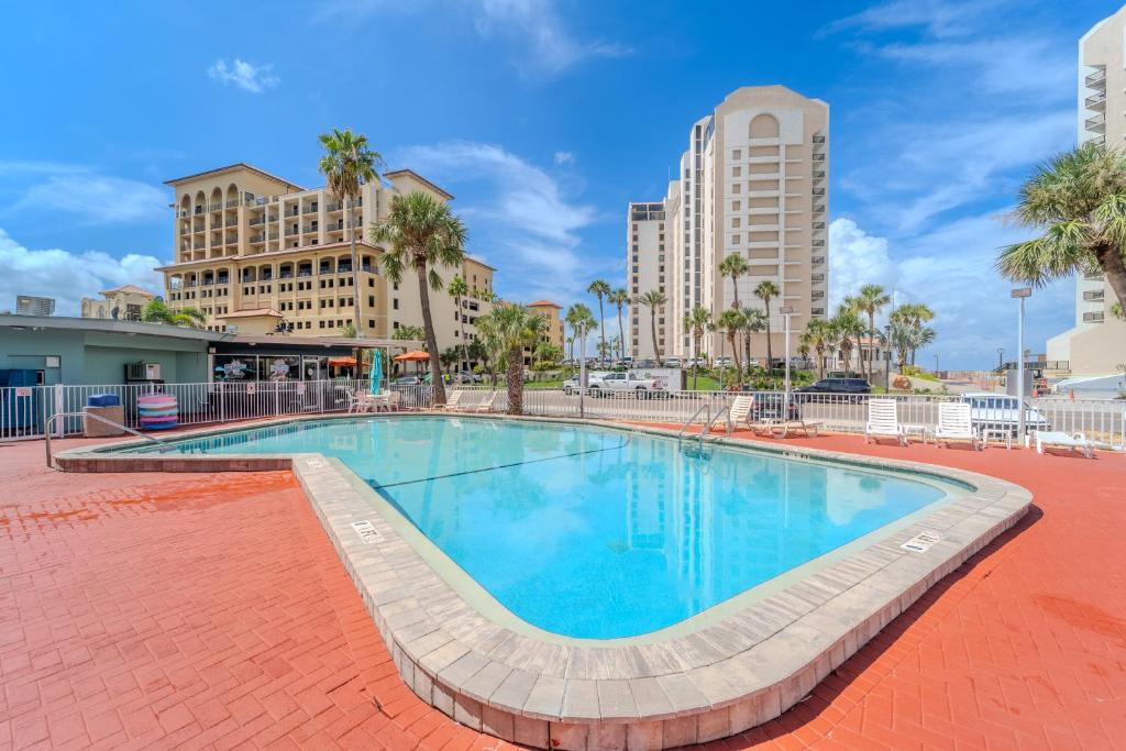 een zwembad met palmbomen en gebouwen bij Abode Beach House in Clearwater Beach
