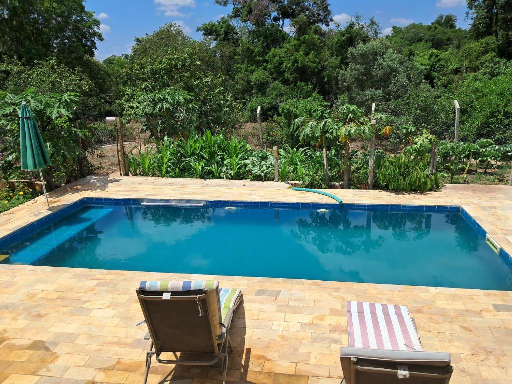 a large swimming pool with two chairs at Casa sitio , Elias Fausto Campinas in Elias Fausto