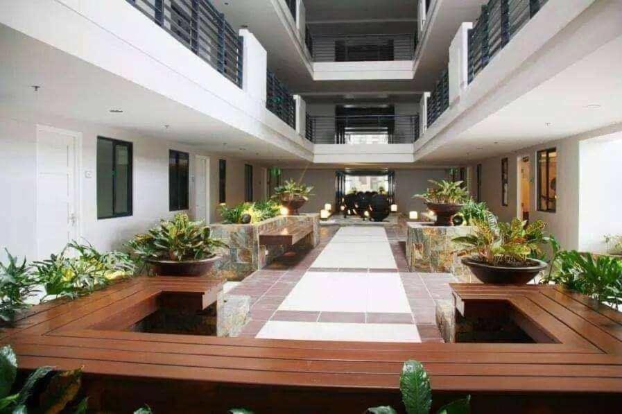 una grande hall con piante in vaso in un edificio di Staycation Condo in Manila a Manila