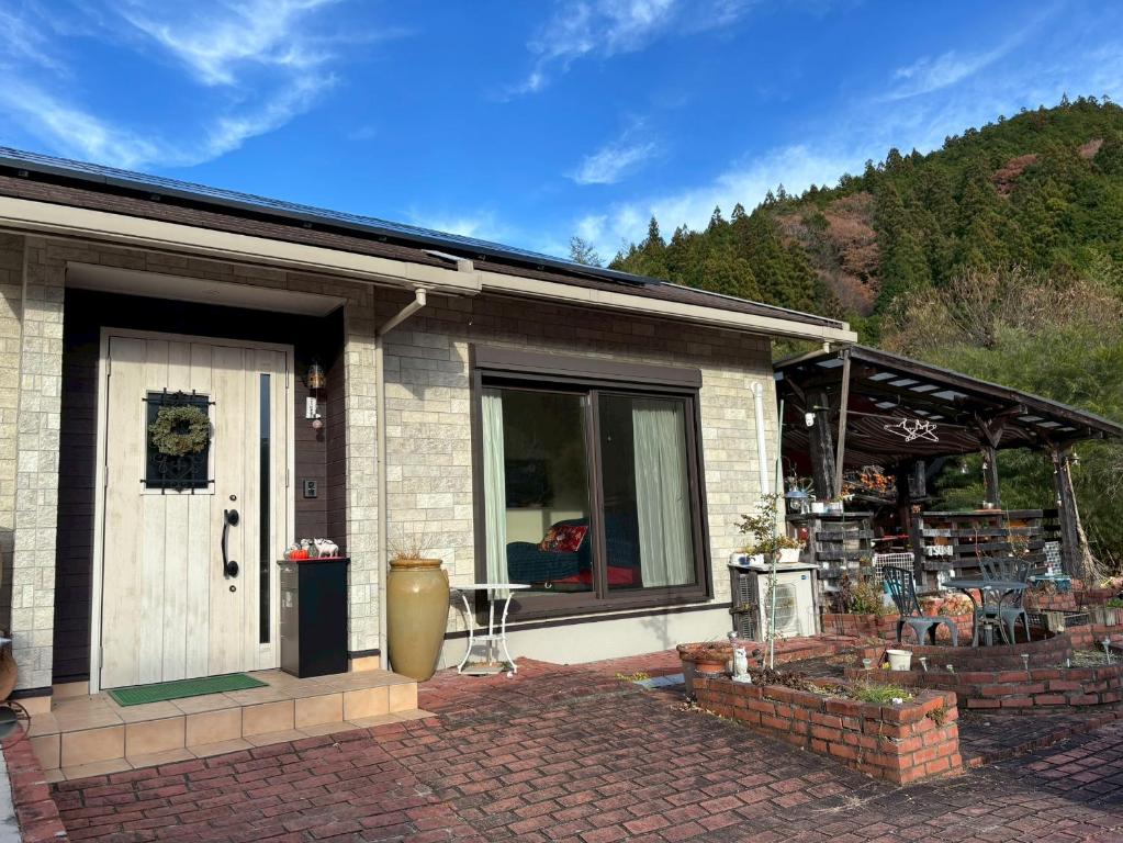 a brick house with a door and a patio at Riverside Garden -kumanokodo-chikatsuyu- in Tanabe