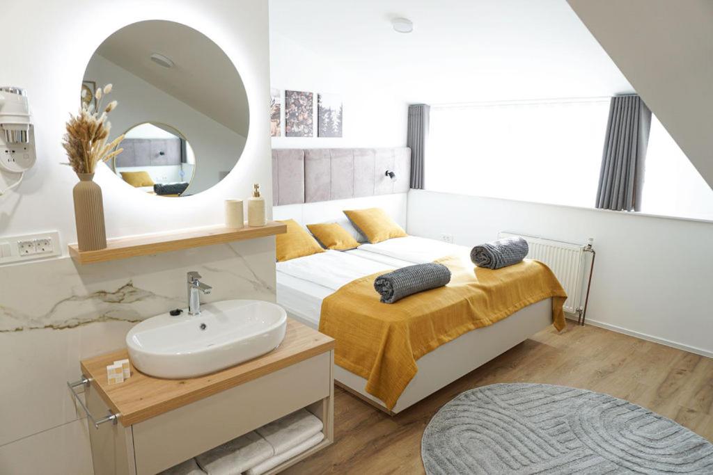 ein Schlafzimmer mit einem Bett mit einem Waschbecken und einem Spiegel in der Unterkunft Gostisce Ulipi in Slovenske Konjice