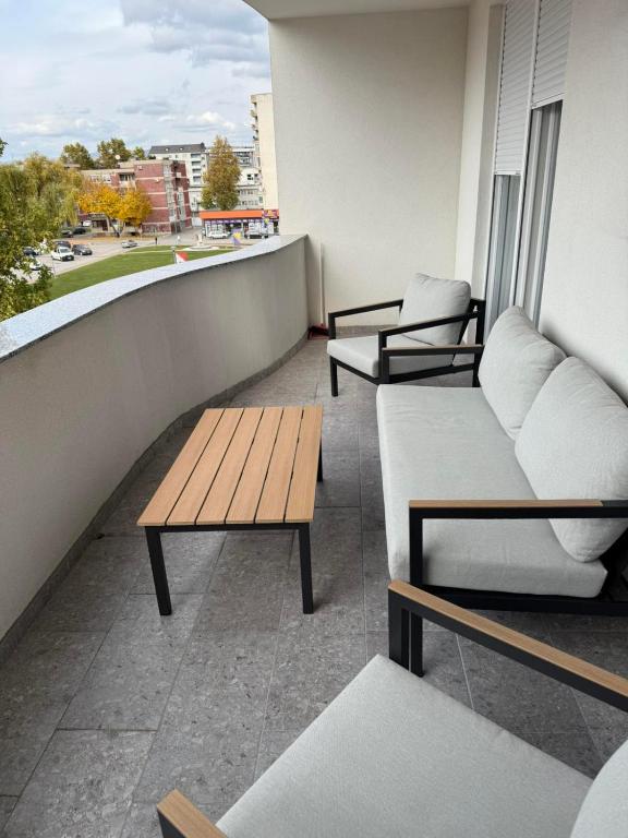 a balcony with couches and tables on a building at Apartman welsh in Bugojno