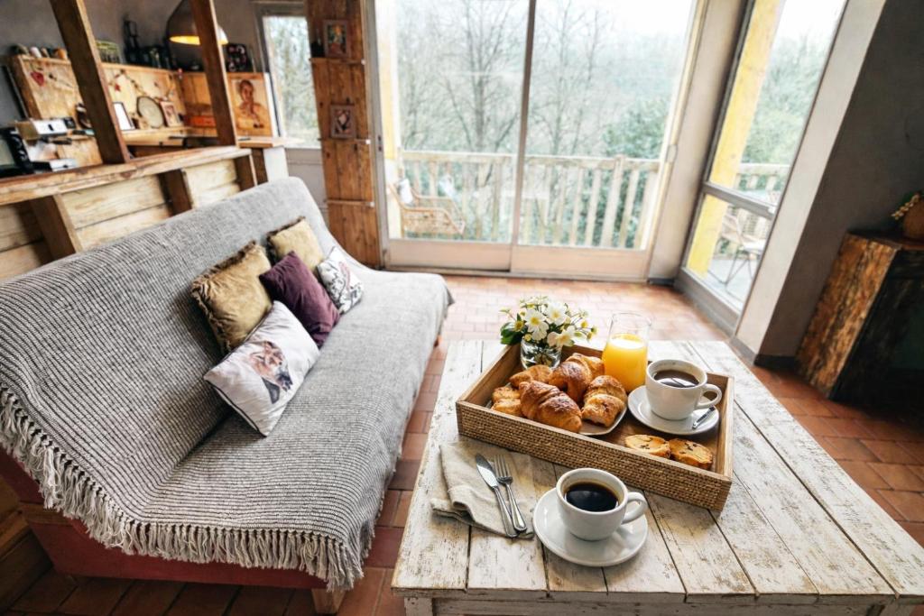 ein Wohnzimmer mit einem Couchtisch mit einem Tablett mit Gebäck in der Unterkunft Maison à 5mn de Honfleur in Fourneville