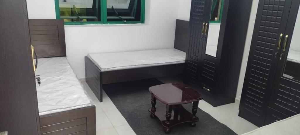 a small bathroom with a bench and a stool at A bedroom with three beds for men only in Sharjah