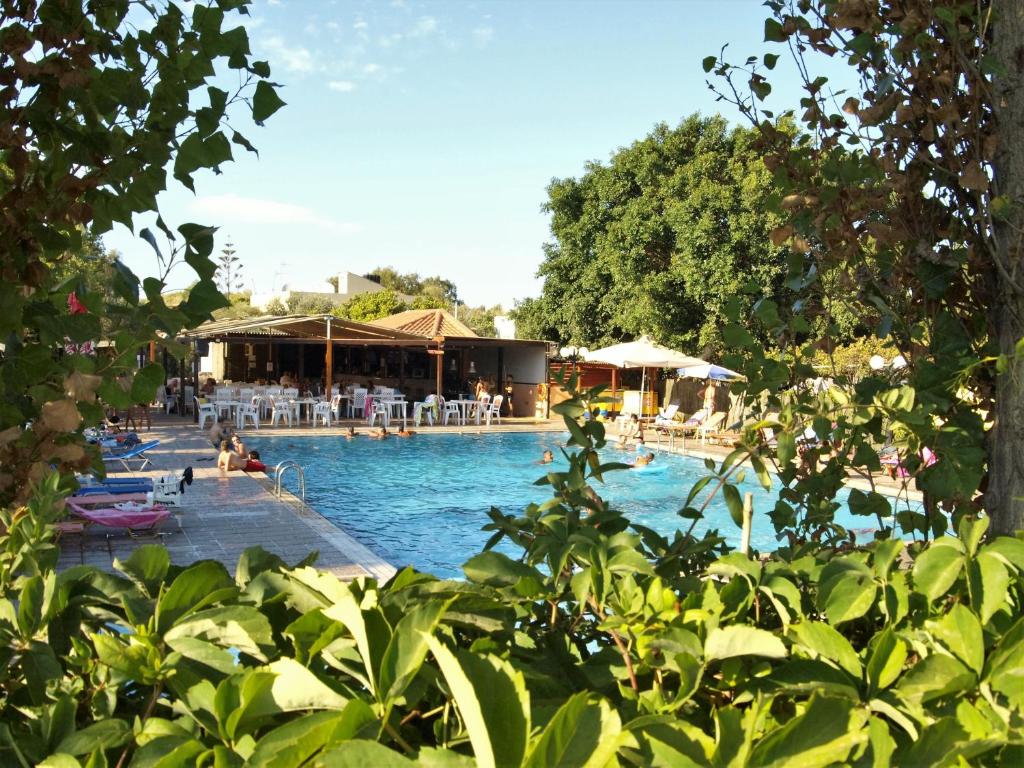 a swimming pool with people sitting in the water at Camping Chania in Kato Daratso