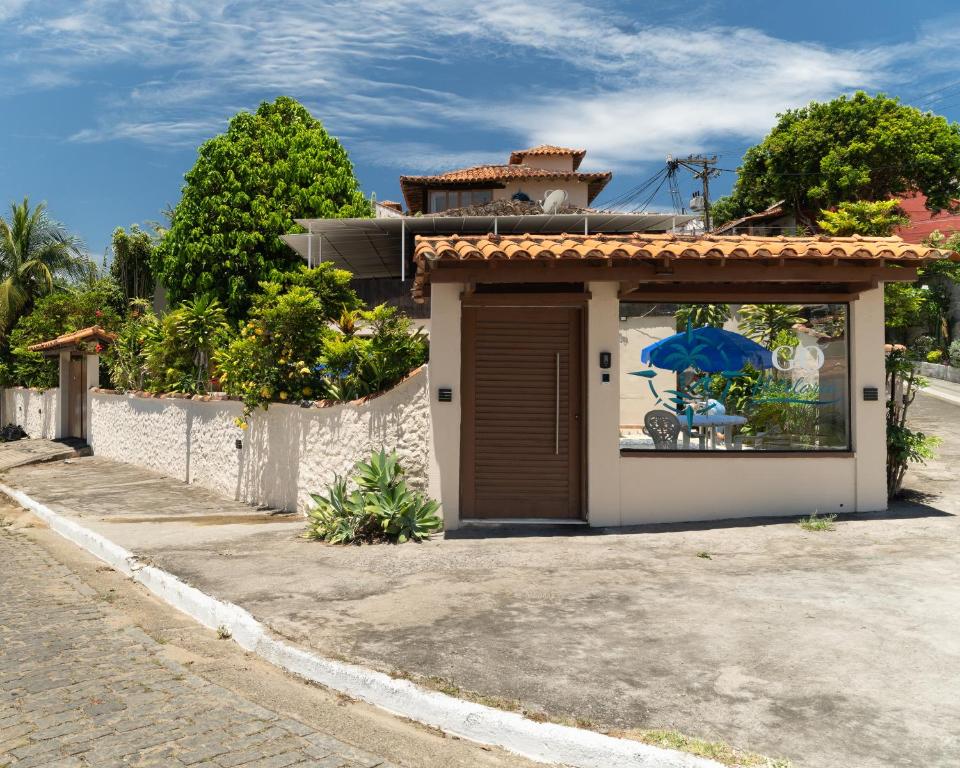 een huis met een garage en een schilderij op het raam bij GO Hotelaria in Búzios