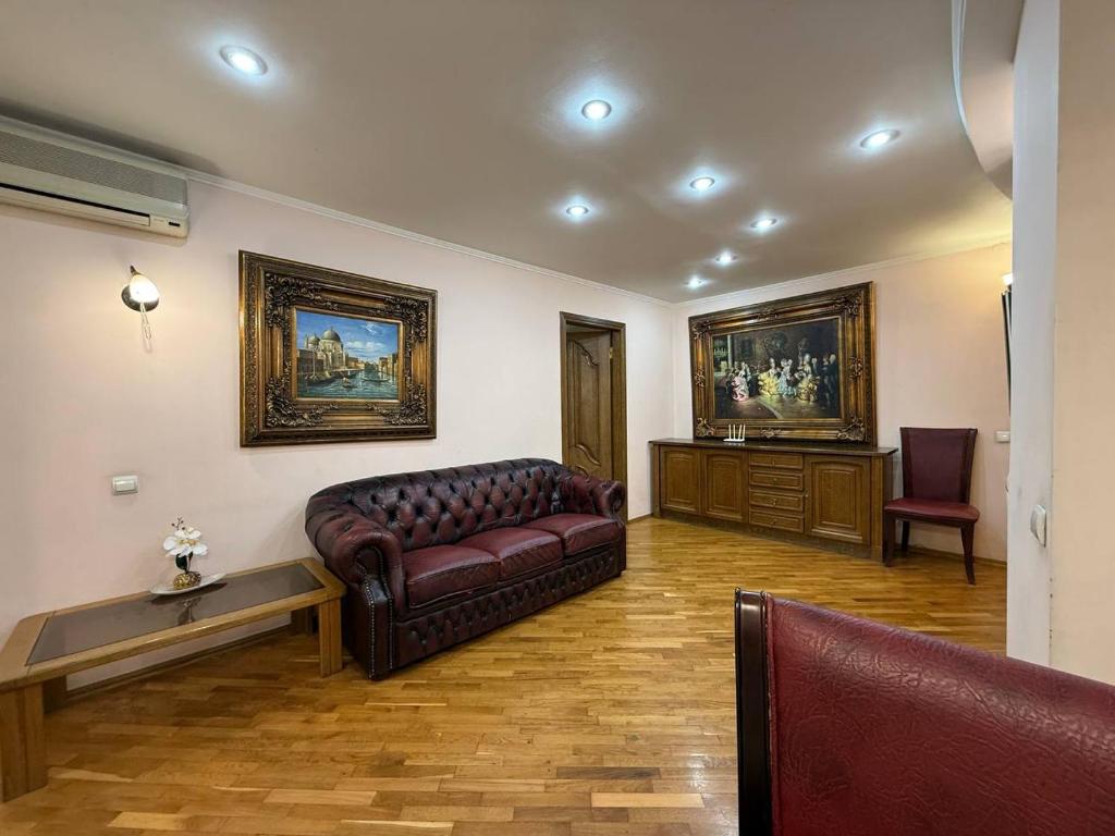 ein Wohnzimmer mit Sofa und Tisch in der Unterkunft Воскресенская 12- 2 кв Евро Центр in Dnipro