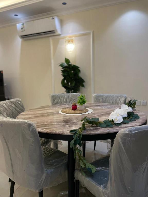 tavolo da pranzo con sedie e ciotola di cibo sopra di جوهرة العزيزية a Dhahran