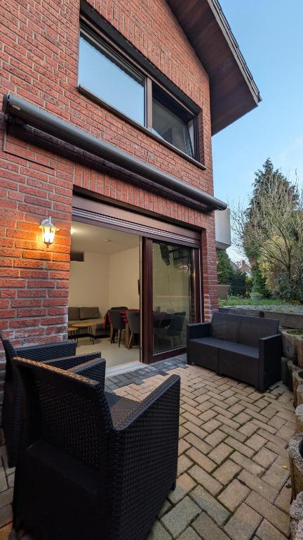 a brick house with two chairs and a patio at Marco City Apartment Werne - Terrasse, Küche & WLAN in Werne an der Lippe