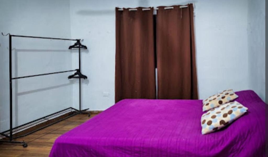 a bedroom with a purple bed with two pillows on it at La casa azul en Ticul Yucatán in Ticul