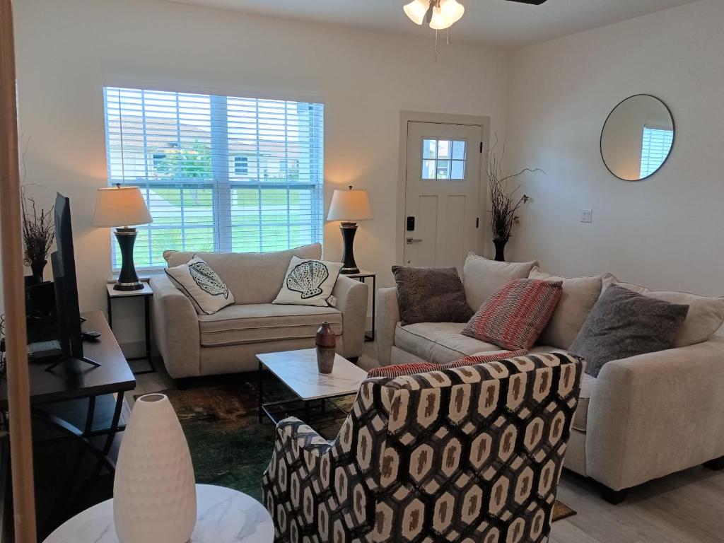 ein Wohnzimmer mit zwei Sofas und einem Fernseher in der Unterkunft Beautiful Room in quiet place shared bath in Ocala