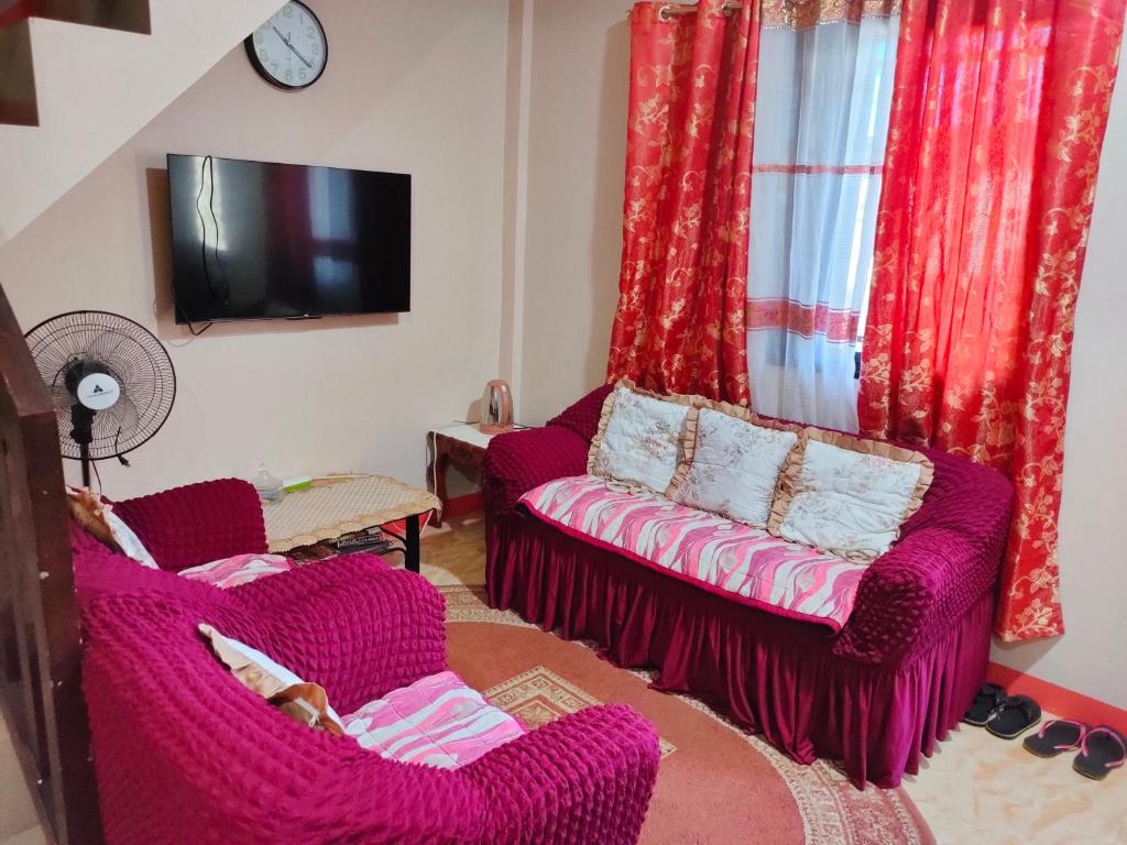 a living room with two chairs and a couch at Eve's Place Transient Apartment in Tanay