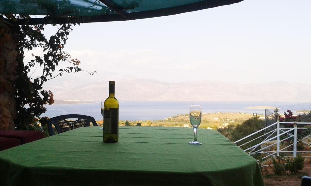 una botella de vino sentada en una mesa con una copa en Santa Xenia, en Galaxidhion