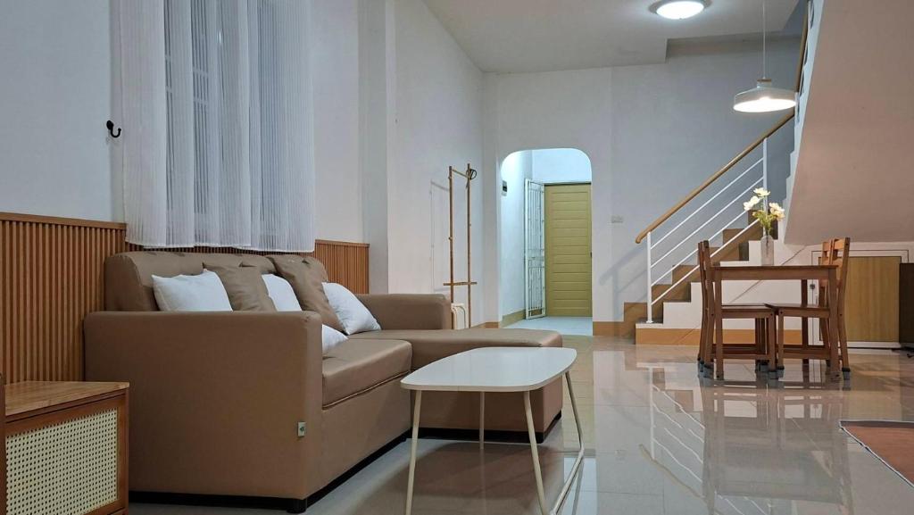 ein Wohnzimmer mit Sofa und Tisch in der Unterkunft บ้านใจฟู URBAN HOMe in Mukdahan