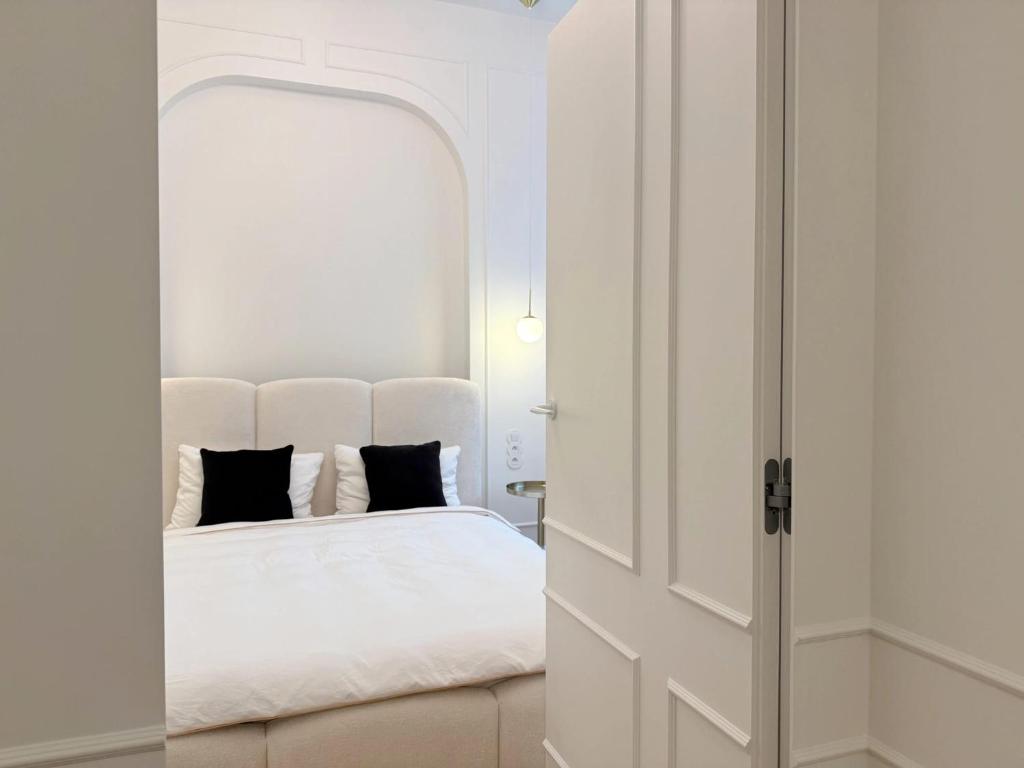 een slaapkamer met een wit bed en een open deur bij Luxury Residence Prime Location Parking in Warschau