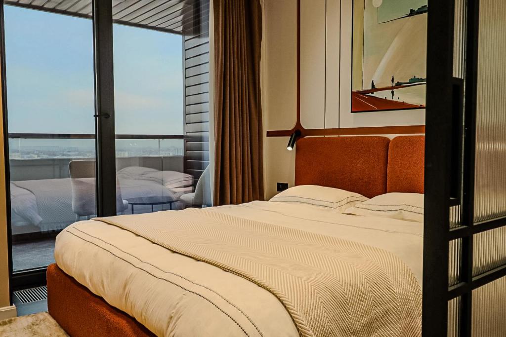 een slaapkamer met een groot bed en een balkon bij Apartments Akash - Tashkent City Residence in Tasjkent