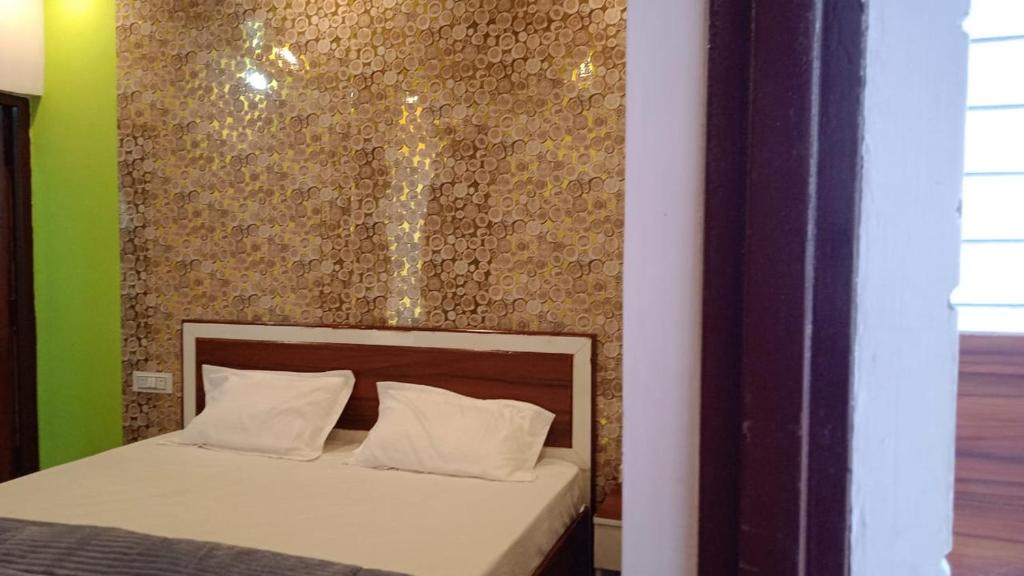 ein Bett mit weißen Kissen und eine Wand mit in der Unterkunft Tree Heaven Homestay in Chamba