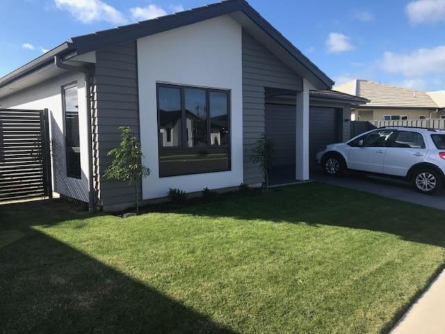 a white car parked in front of a house at Parklands paradise 3bedroom4beds in Napier