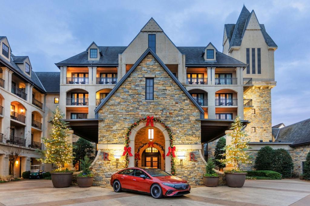 une voiture rouge garée devant une grande maison dans l'établissement Renaissance Birmingham Ross Bridge Golf Resort & Spa, à Hoover