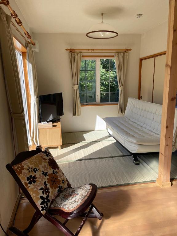 a living room with a bed and a chair at aomame villa lake toya in Lake Toya