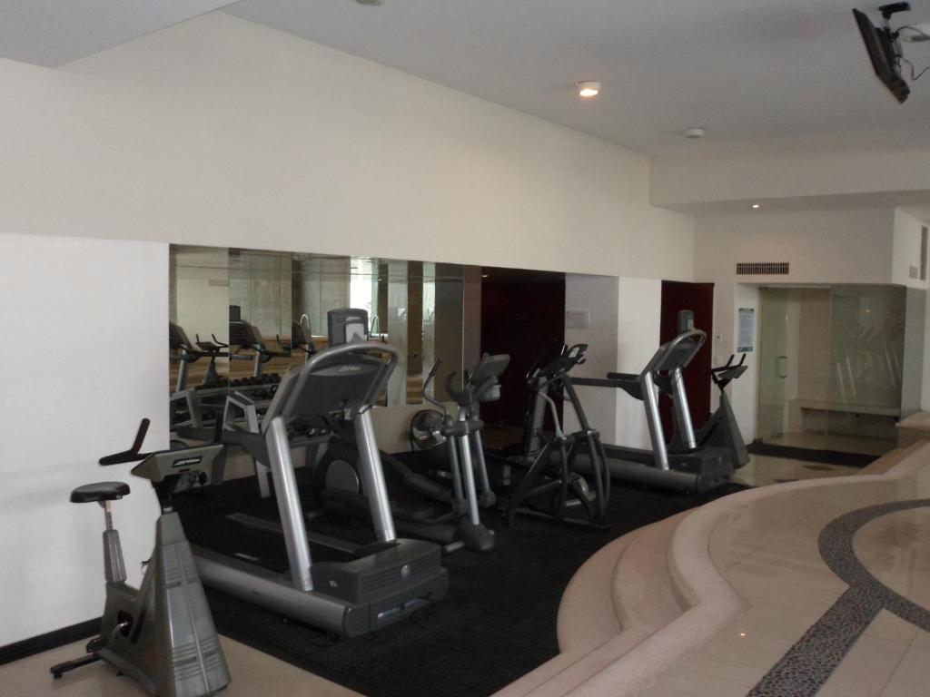 A compact mirrored fitness room is equipped mainly with cardio machines.