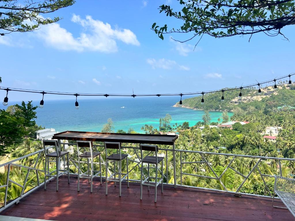 a table and chairs on a deck overlooking the ocean at Seaview Love Nest in Ko Phangan
