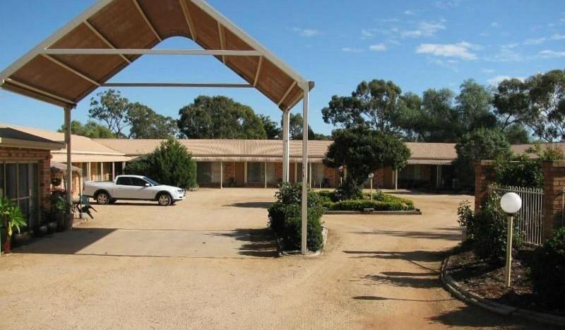 a car parked in a parking lot in front of a building at Lucky Strike Motel in Tomingley