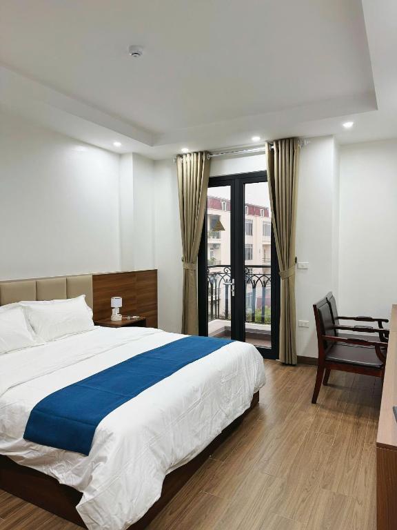 a bedroom with a large bed and a balcony at Cheng Hotel - 怀庄酒店 in Hòa Ðình