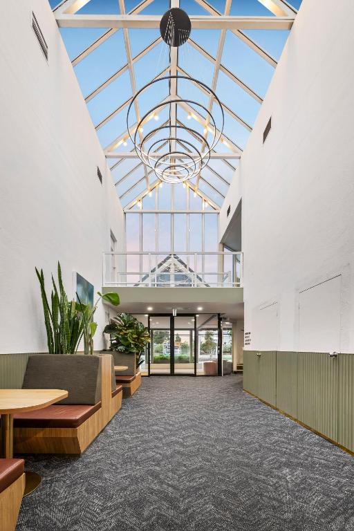 an empty lobby with a large glass ceiling at Ciloms Airport Lodge Melbourne Airport in Melbourne