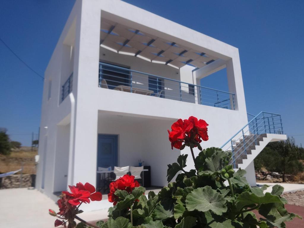 a white house with red flowers in front of it at Eureka Kythira in Kythira