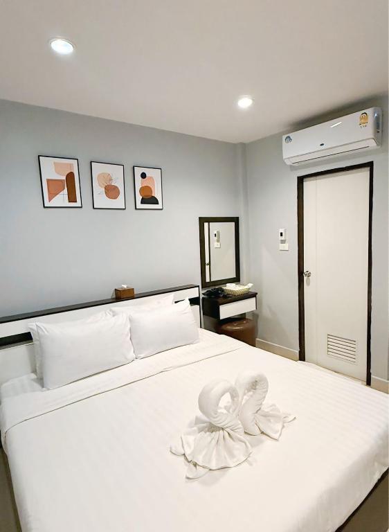 a bedroom with a white bed with flowers on it at Sampheng Apartment in Bangkok