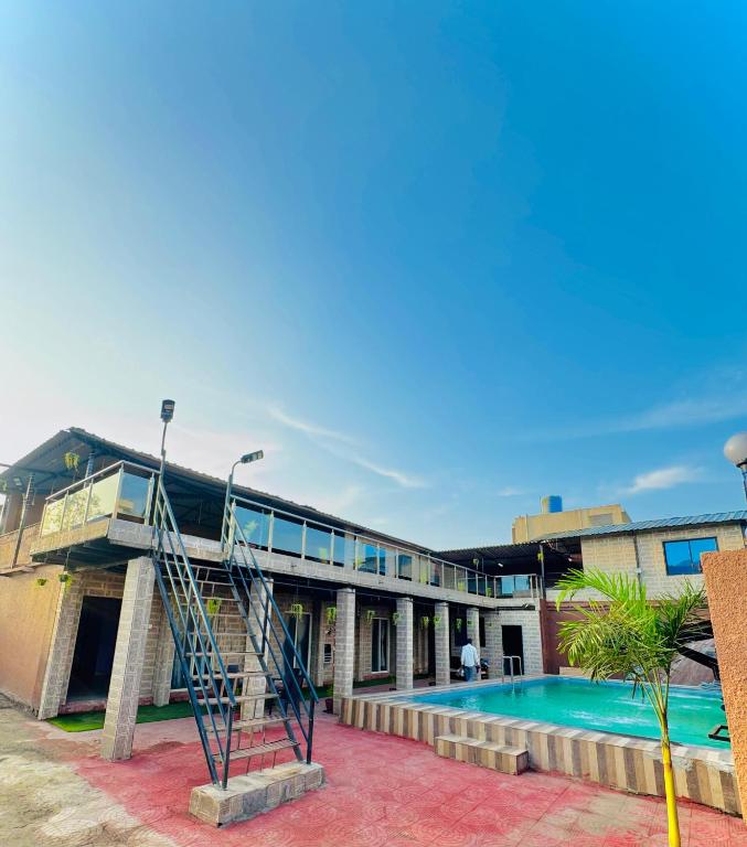 een gebouw met een zwembad en een trap ernaast bij empire villa in Malavli