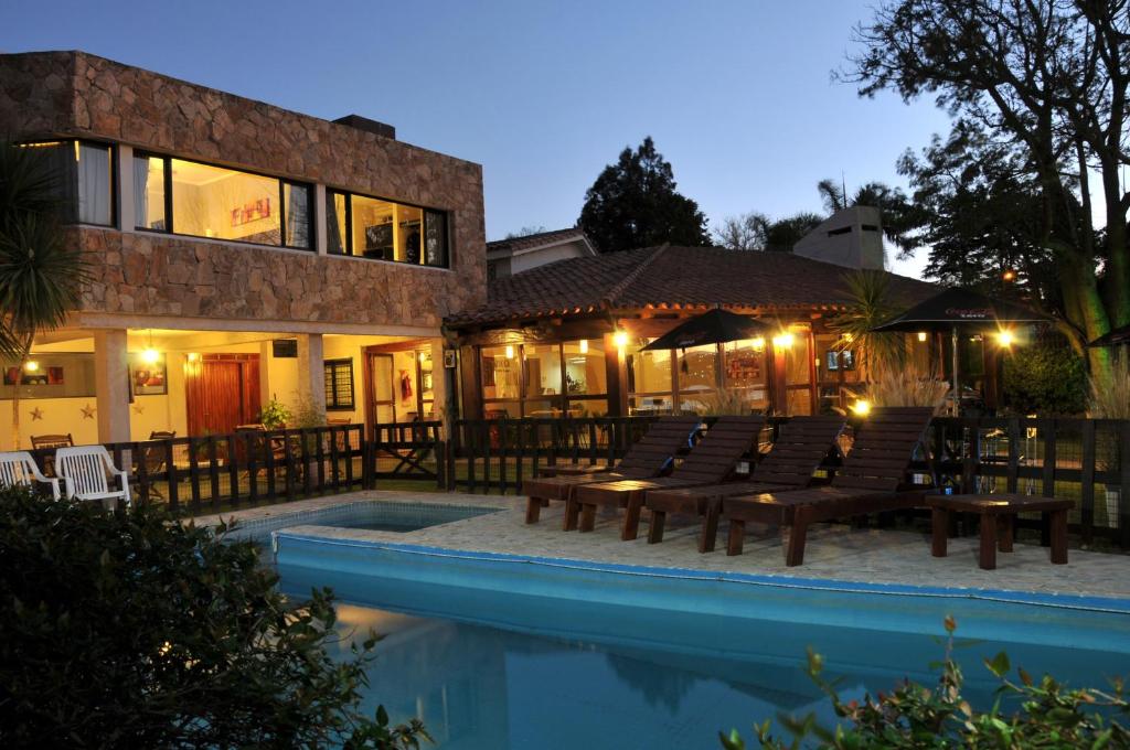 un complexe avec une piscine et un bâtiment dans l'établissement Madeo Hotel & Spa, à Villa Carlos Paz