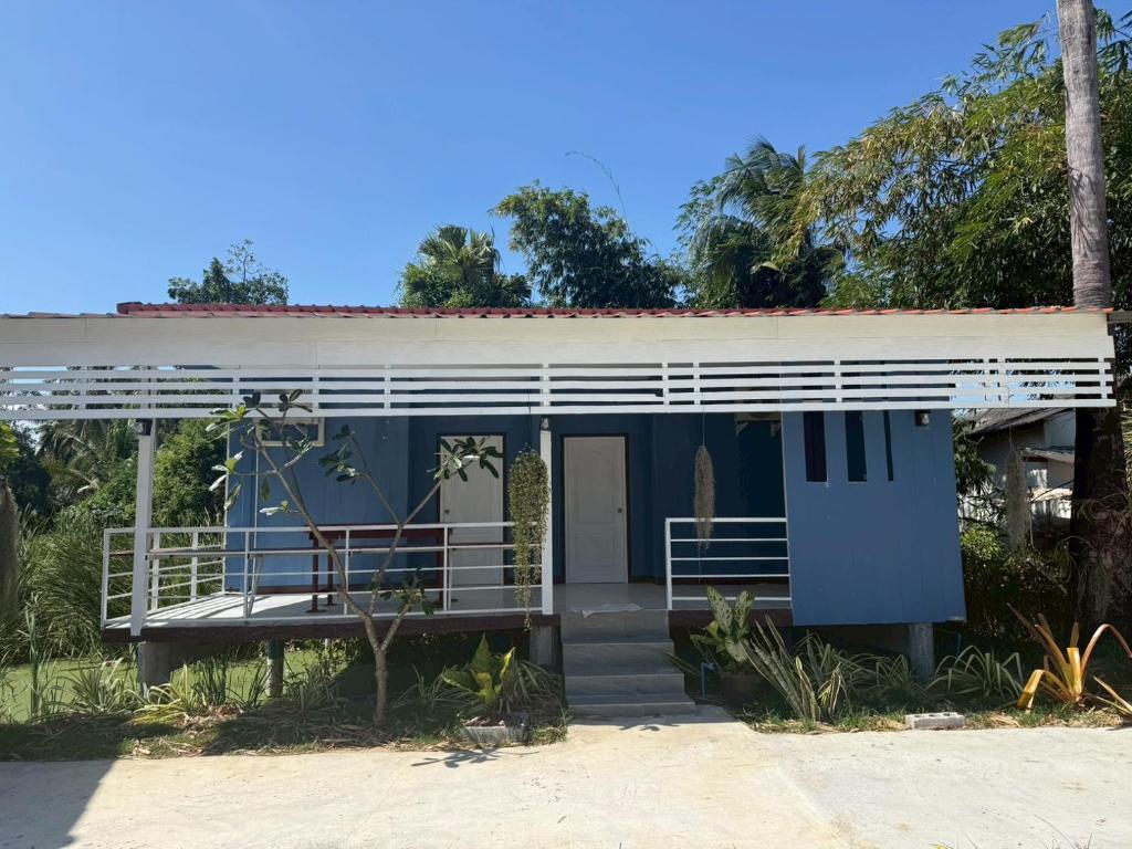 a blue house with a porch and a balcony at ต้นตาล&ตาลฟ้า รีสอร์ท in Ban Nong Khang