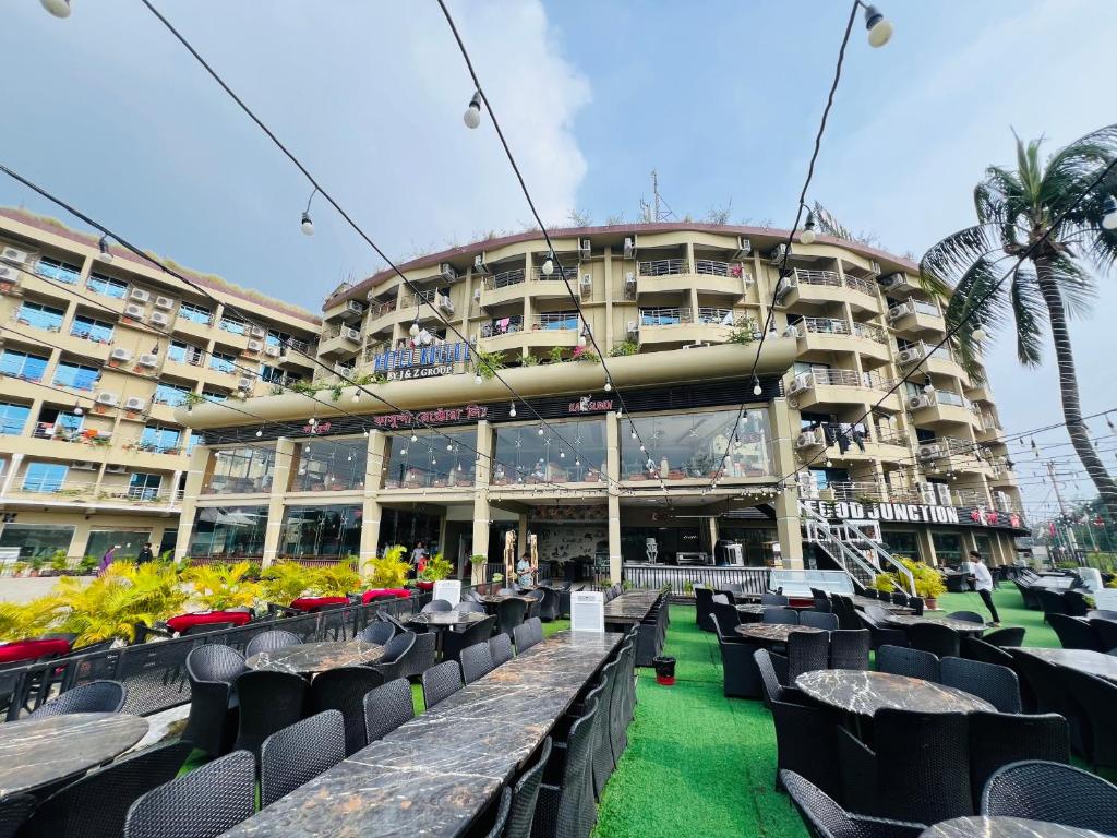a building with tables and chairs in front of it at Hotel Kollol by J&Z Group in Cox's Bazar