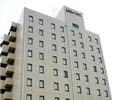 a tall white building with many windows at Hotel Crown Hills Yuki in Yuki