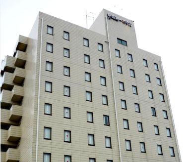 Un grand bâtiment blanc avec de nombreuses fenêtres dans l'établissement Hotel Crown Hills Yuki, à Yuki
